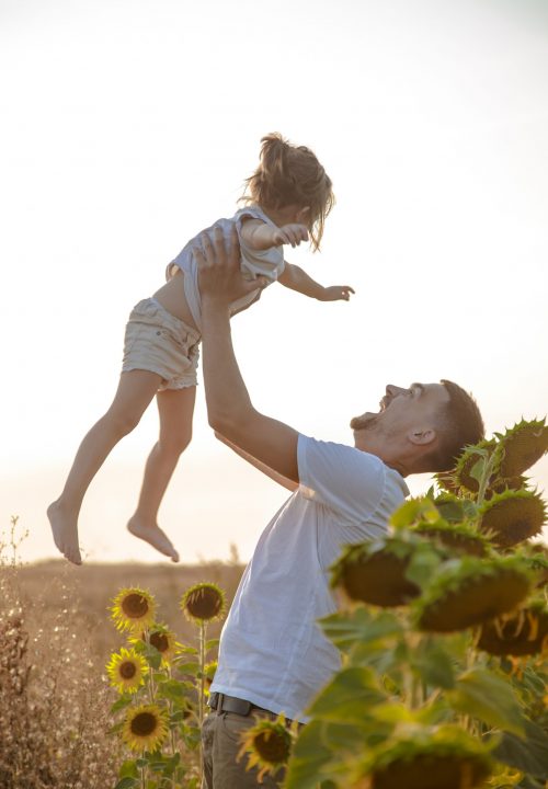 Happy family, dad with a little daughter playing in the field at sunset. The concept of family values and friendship.